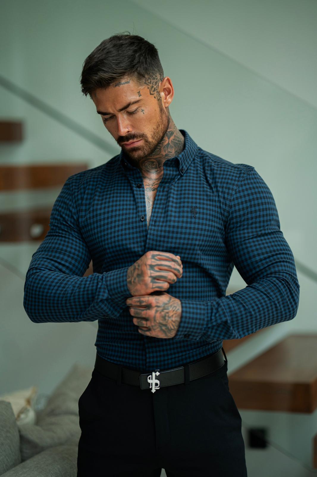 A man wearing a blue and black checkered, super slim fit dress shirt with the Father Sons tonal black emblem.